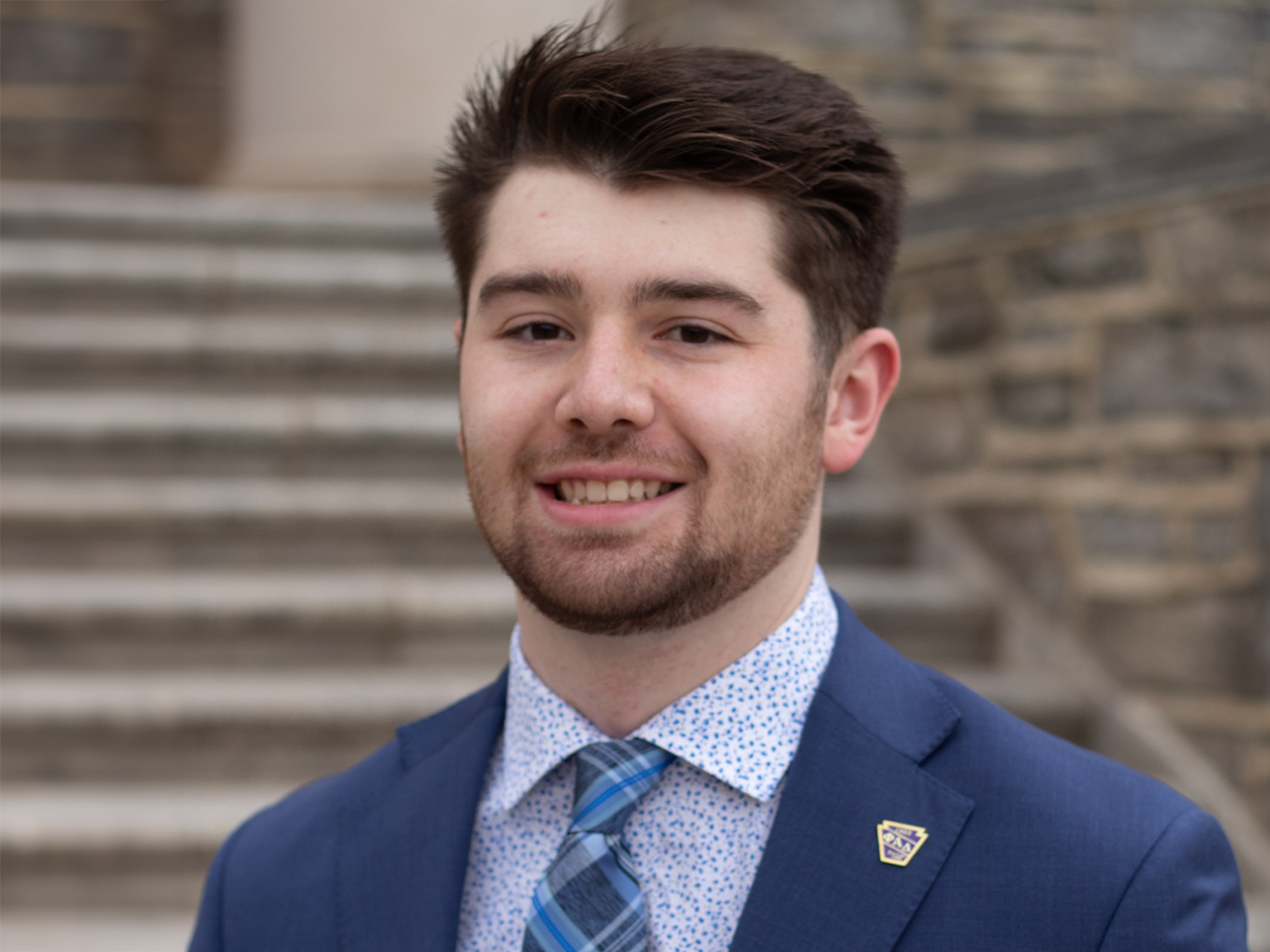 : Reese Hays stands in front of Old Main at Penn State University Park.