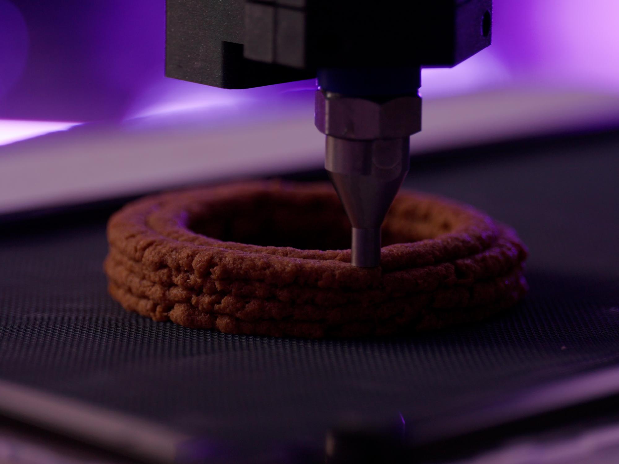 3D printer printing a ring shape with mycelium paste