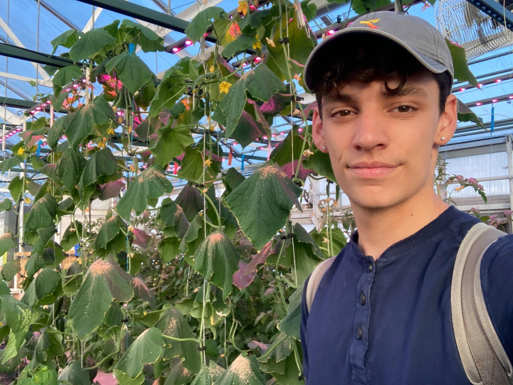 Jimmy Alamia stands in front of flowering plants
