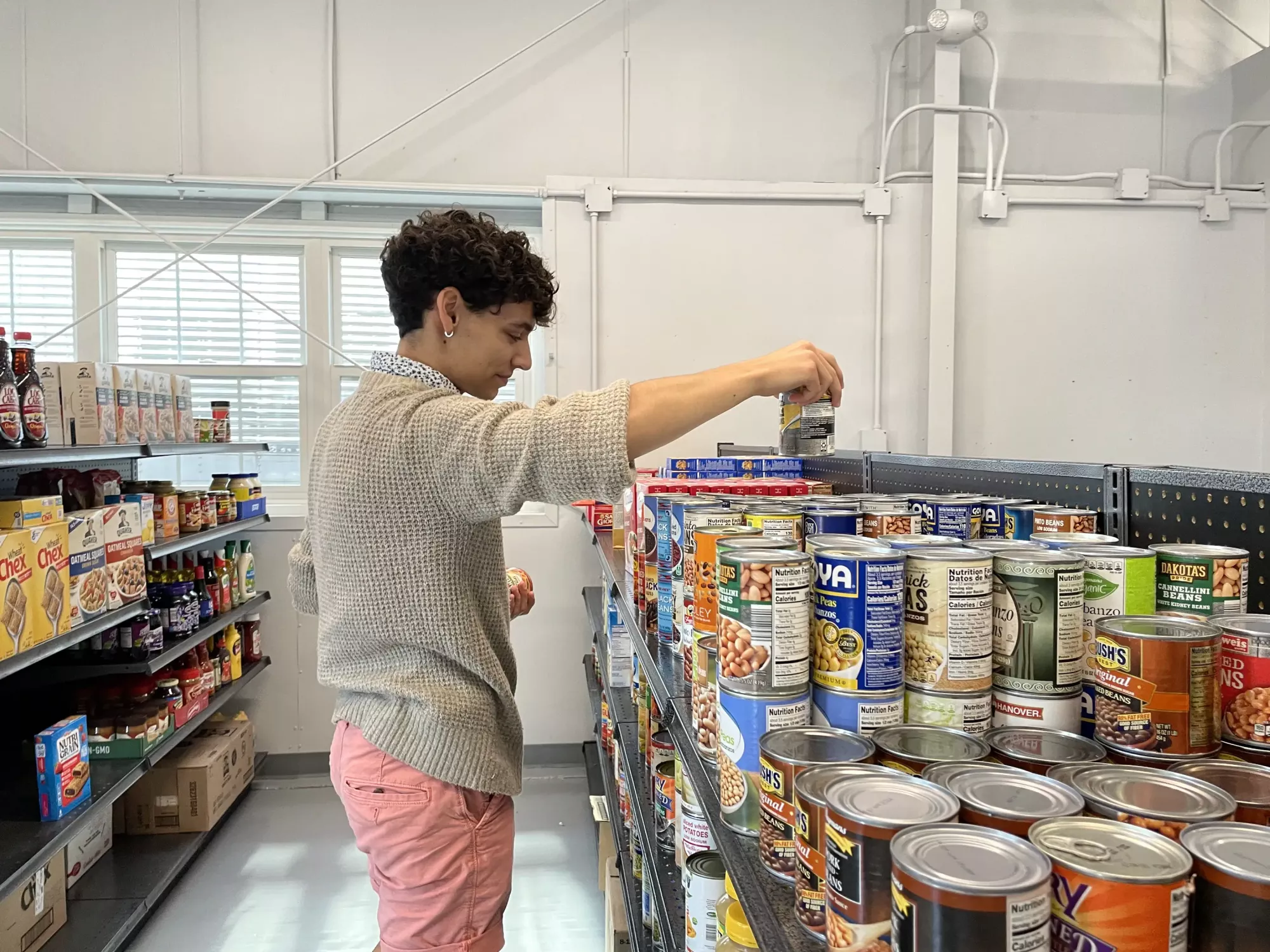 Jimmy Alamia stocks canned goods at the Lion's Pantry