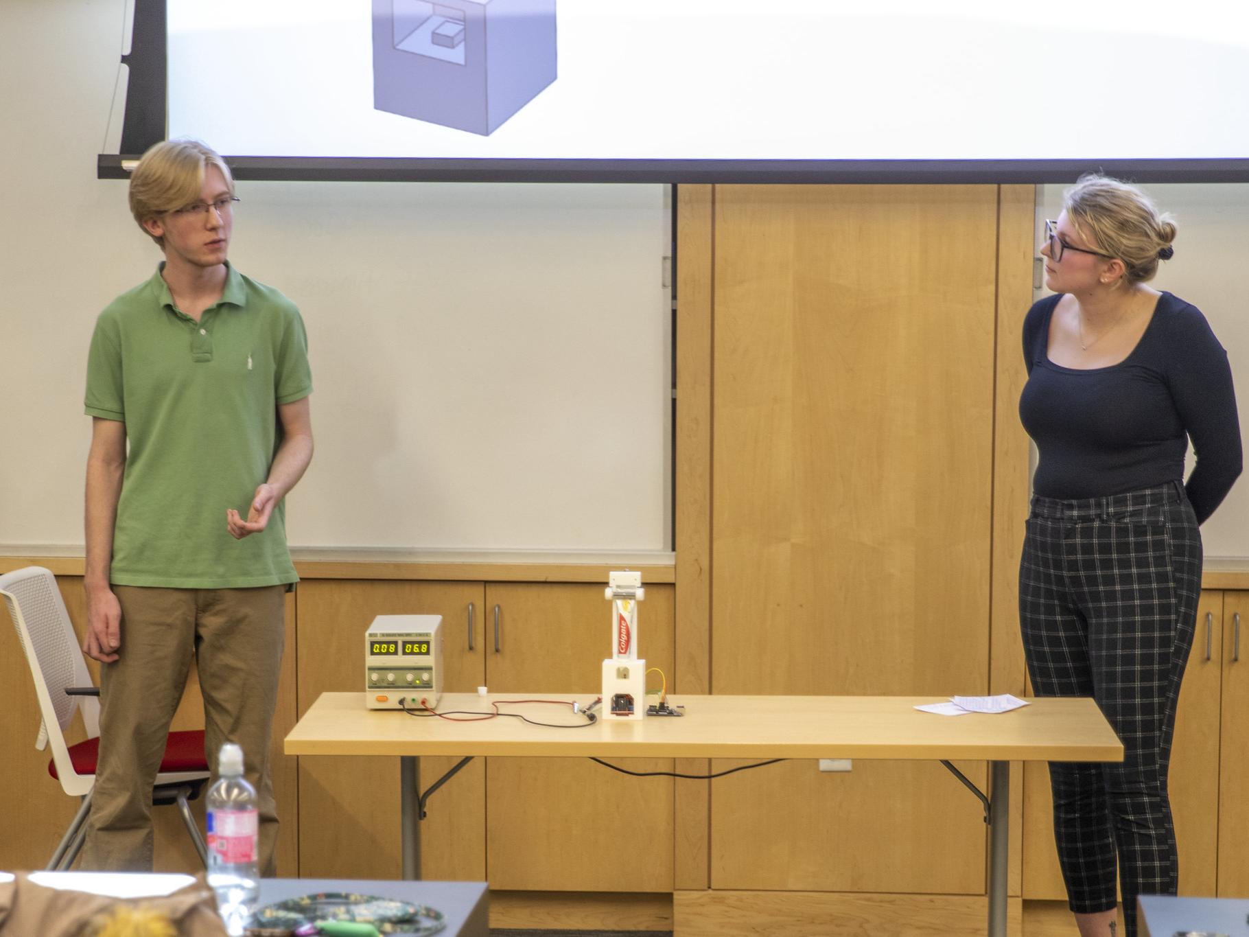 Female and male student present automatic toothpaste dispenser