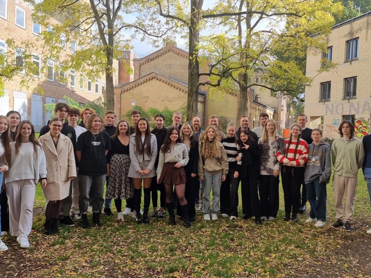 A large group of youths standing in a semicircle outside