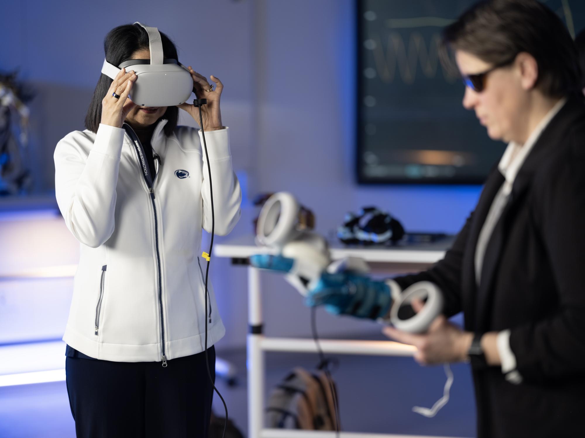 Neeli wears an Oculus virtual reality headset while Laura sculpts in the air wearing a haptic glove. 