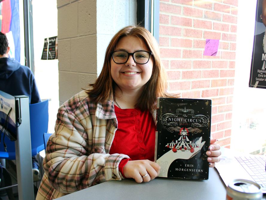 Student Kiera Langan smiles while showing off her book of choice "The Night Circus".