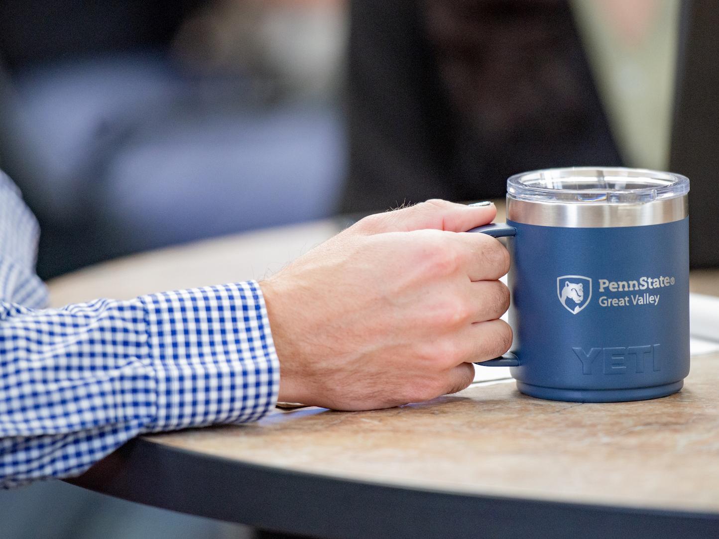 Someone holding a great valley coffee cup 