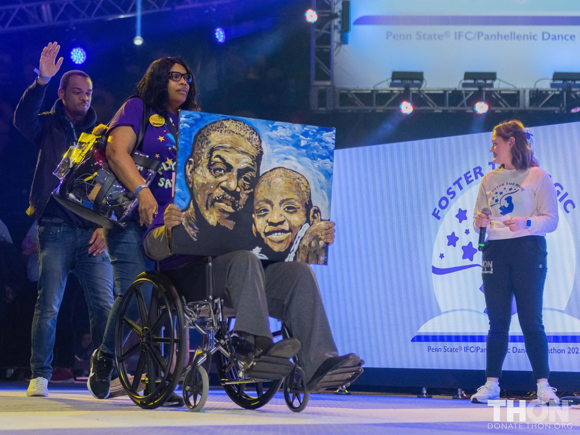 People on stage at THON weekend. One person is in a wheelchair