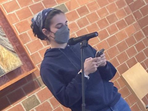 Student Paige McCusker reads a poem by Mahmoud Darwish.