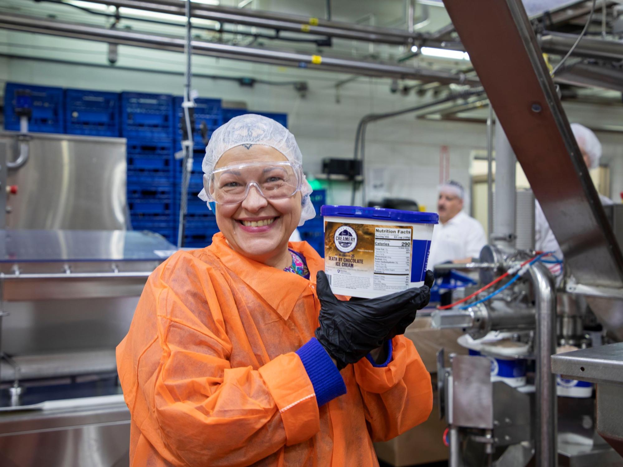 production worker in food factory holding ice cream container