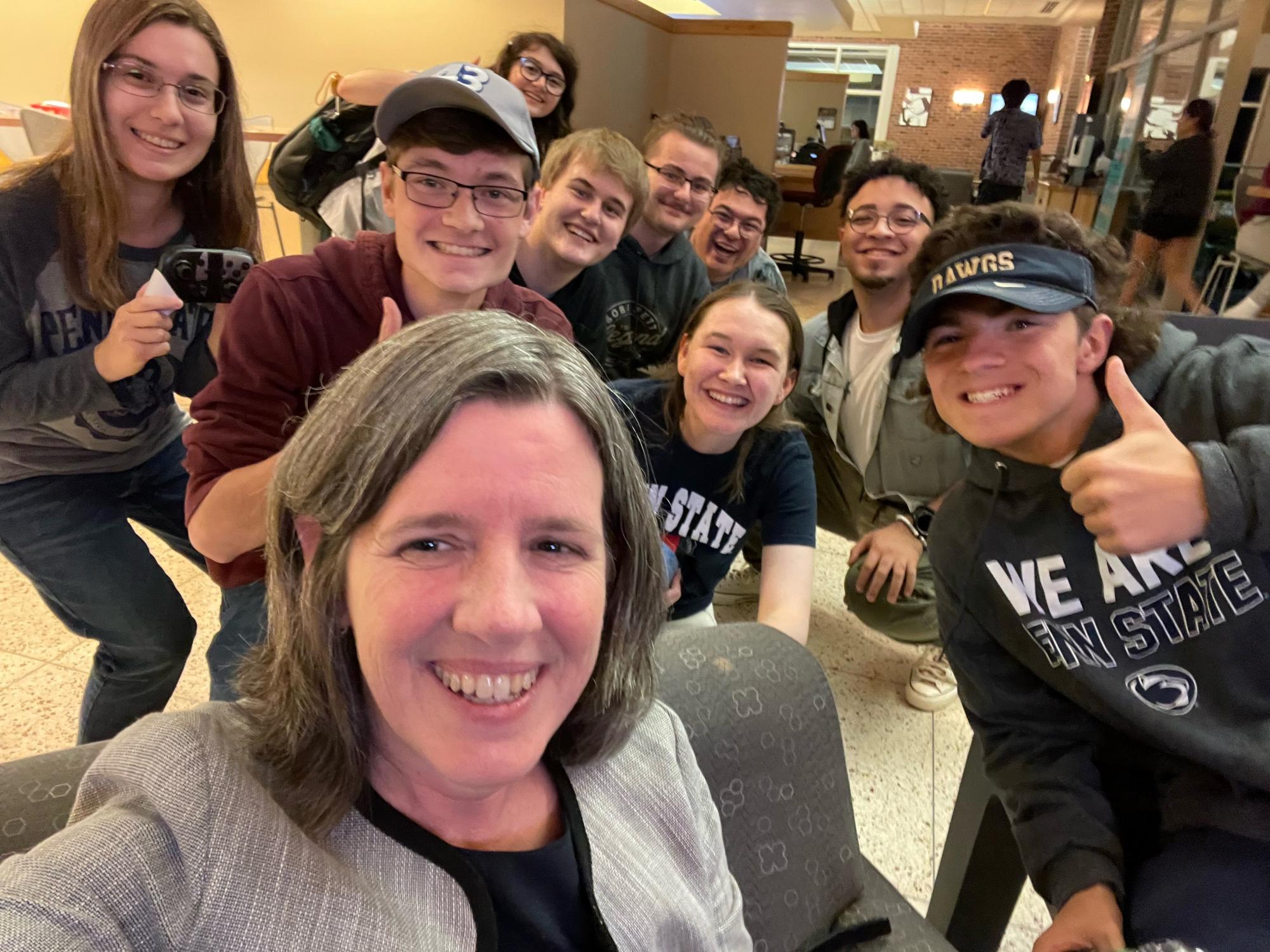 A group of people huddled together posing for a selfie.