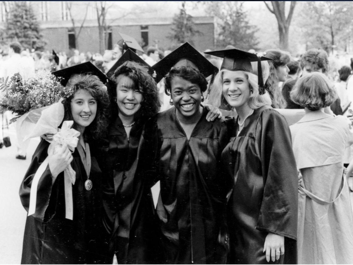 A group of four women wearing graduation caps and gowns