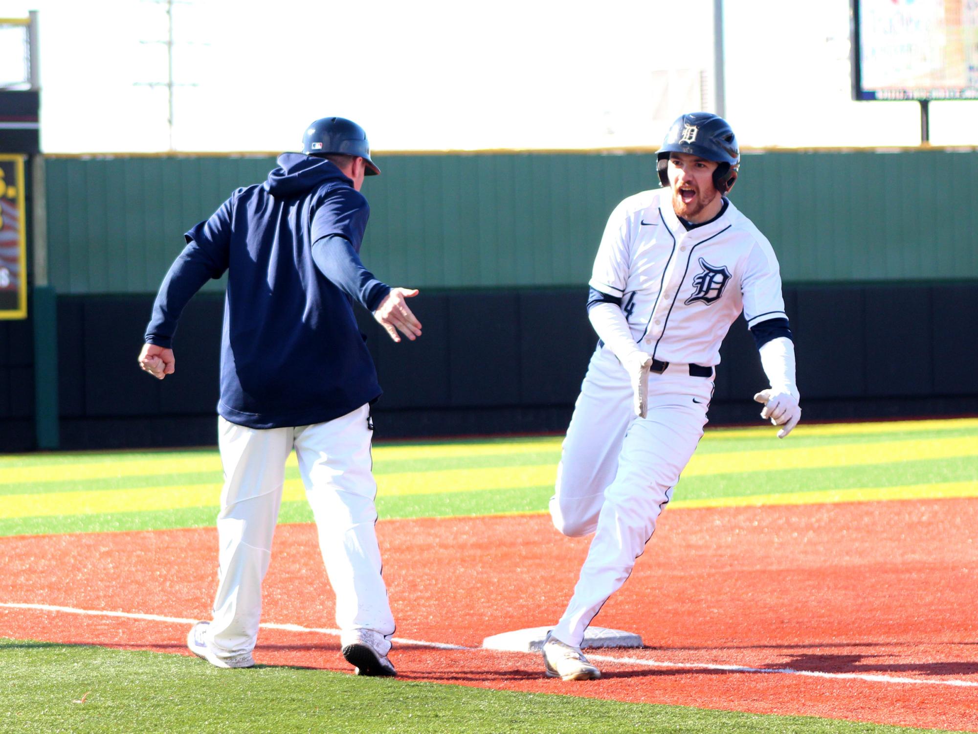 Penn State DuBois senior outfielder Brandon Sicheri celebrates his home run with assistant coach Garrett Brown as he rounds third base during a recent home game at Showers Field in DuBois.