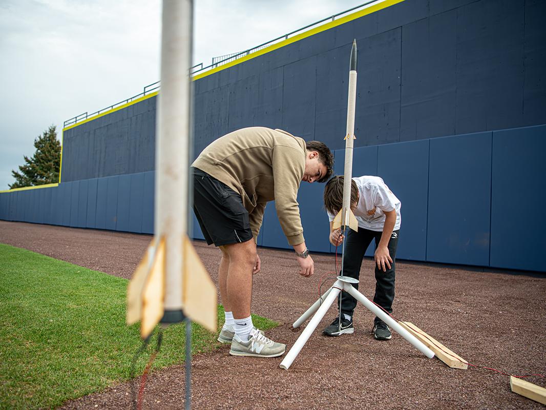 Two people prepare to launch rockets
