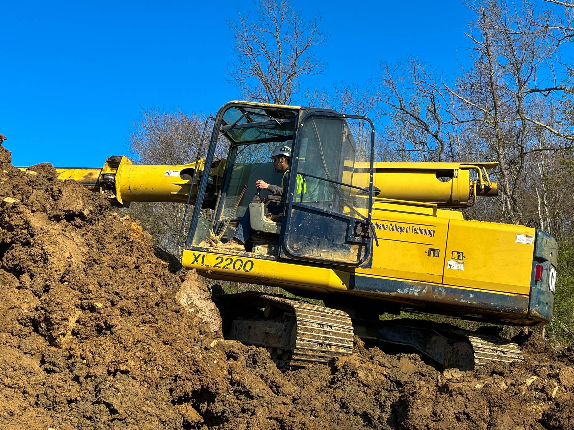 A big piece of machinery doing some construction over muddy ground