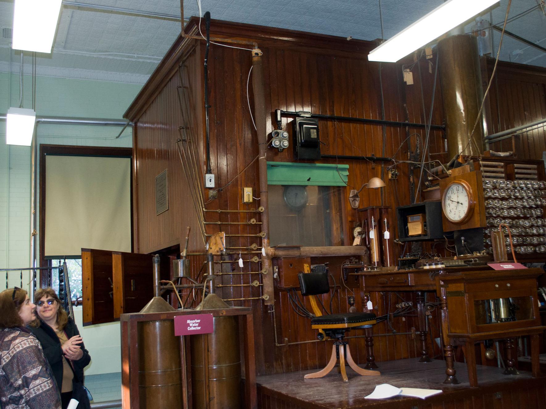 Two women look up at the Calorimeter, a wooden construct that measured metabolistic rates of animals and humans.