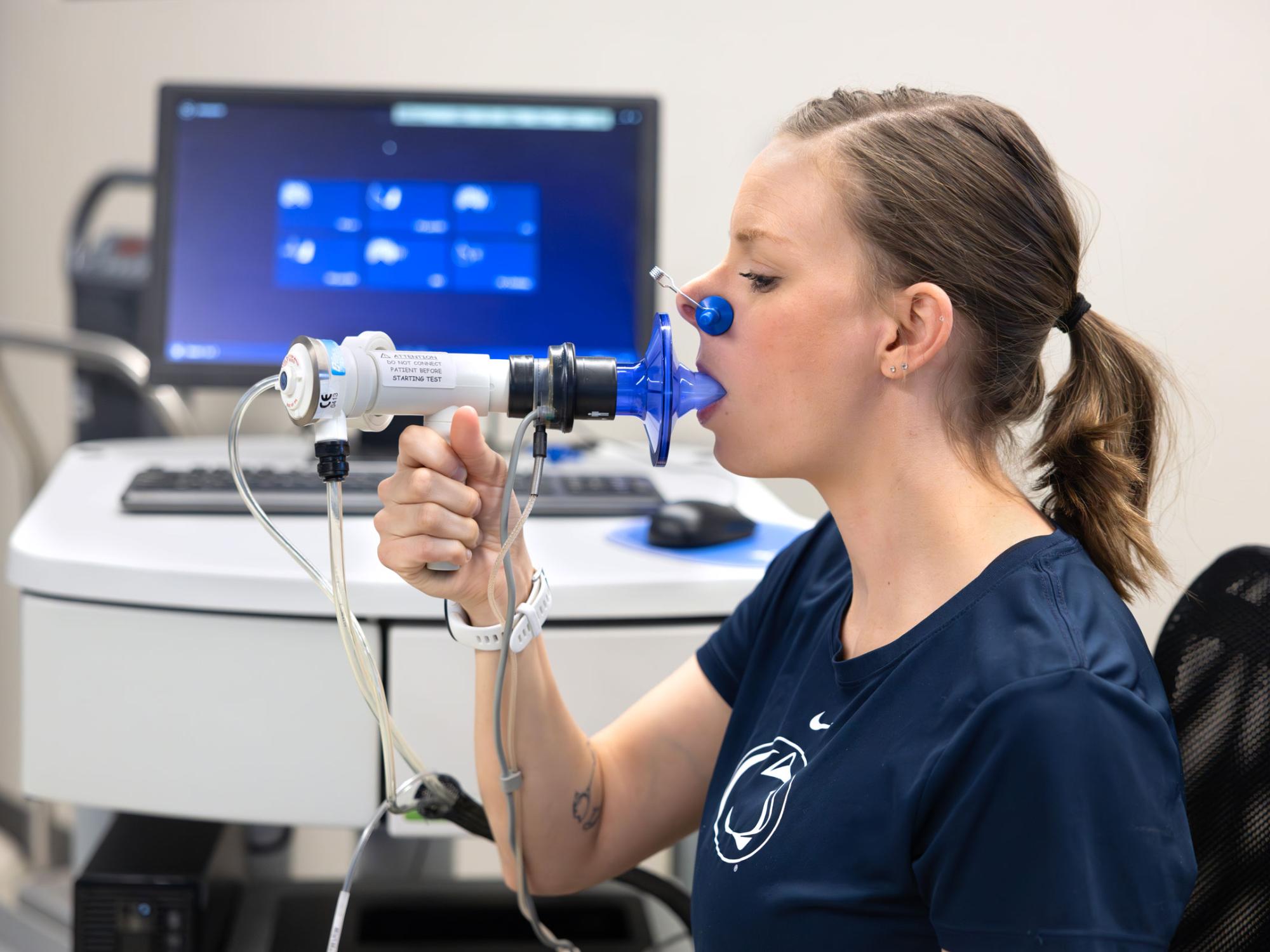 A patient uses a spirometer to perform a pulmonary function test