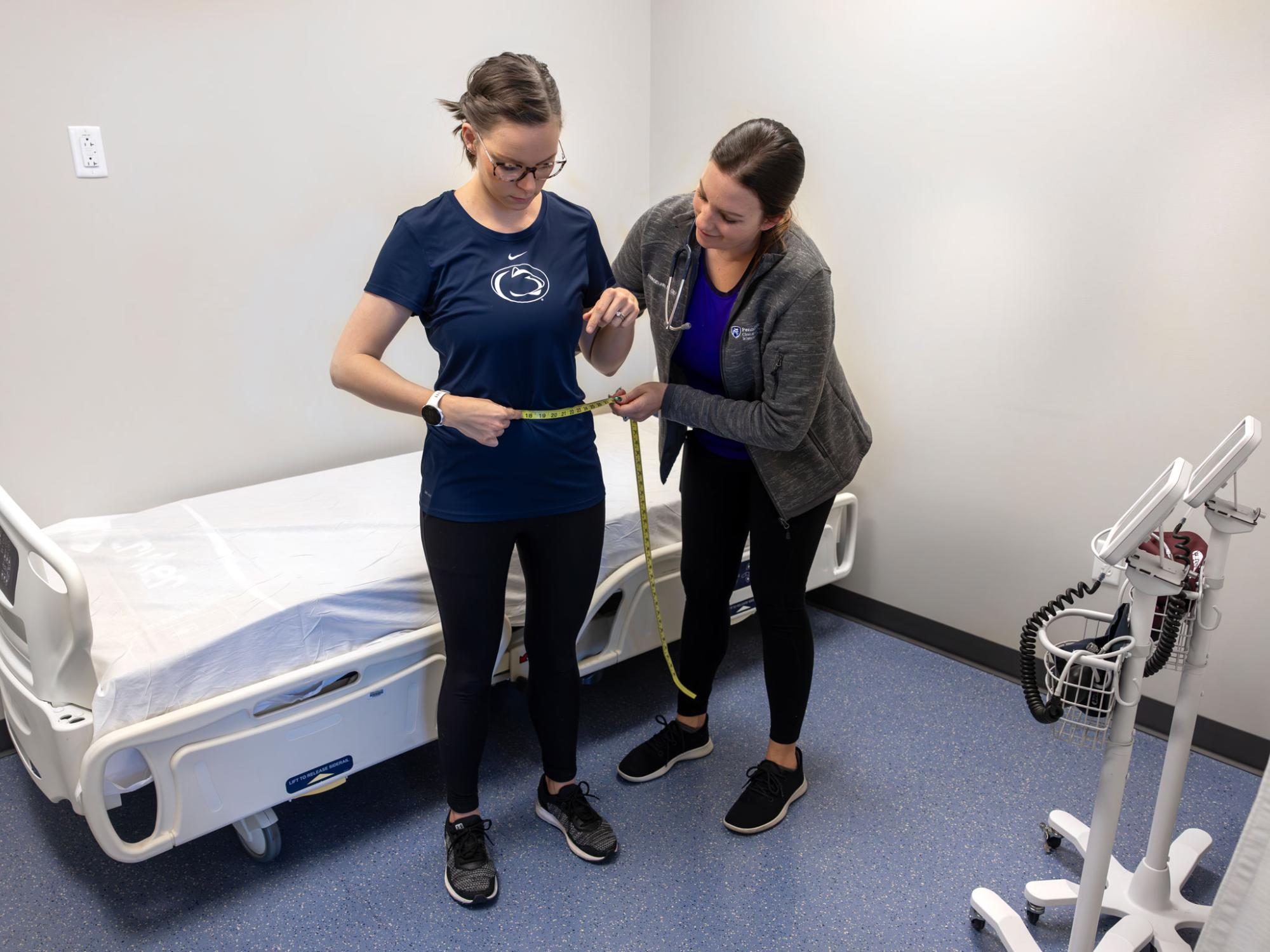 ERC manager measures the patient’s waist circumference in a private exam room