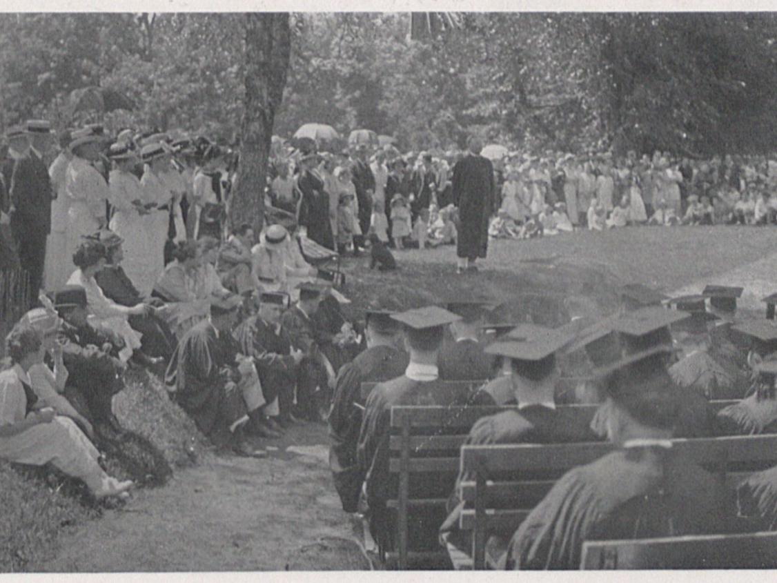A group of bystanders watch a graduation reception in 1915