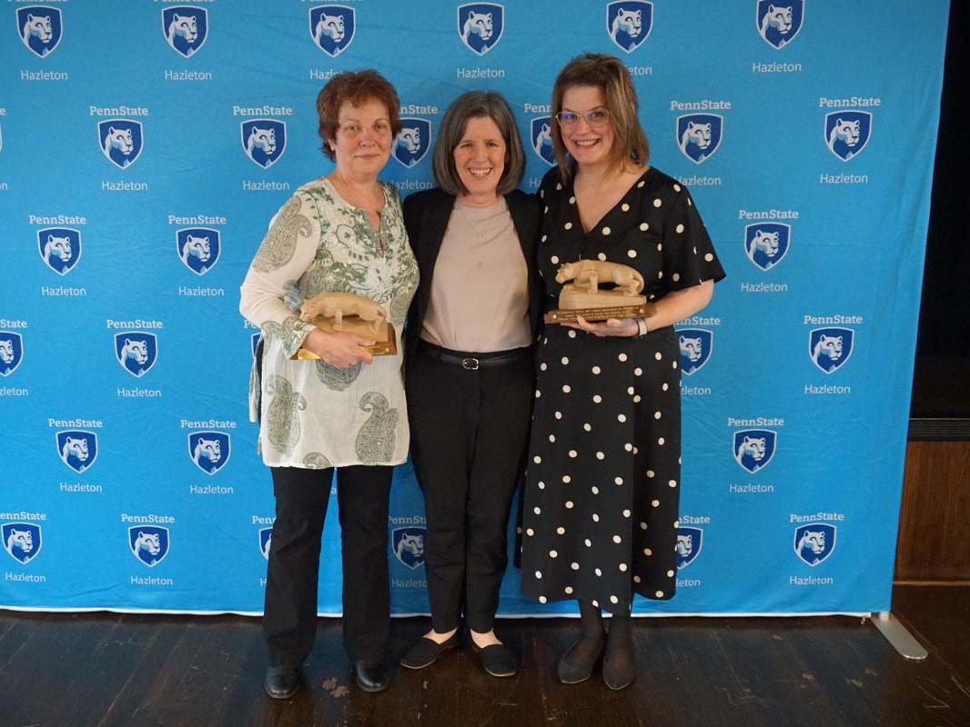 Three women standing in front of light blue Penn State Hazleton backdrop.
