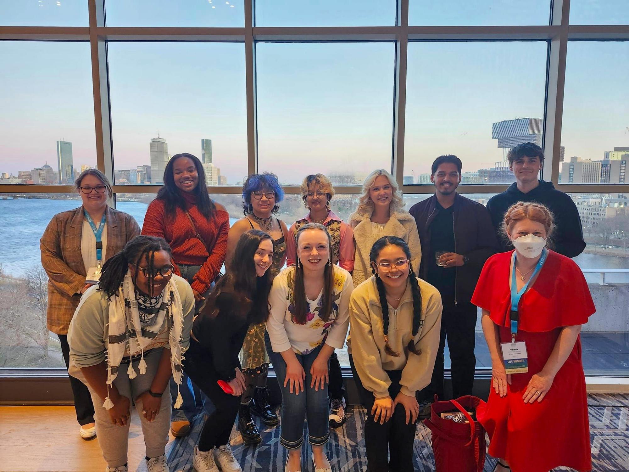 group of people standing in front of window with city view