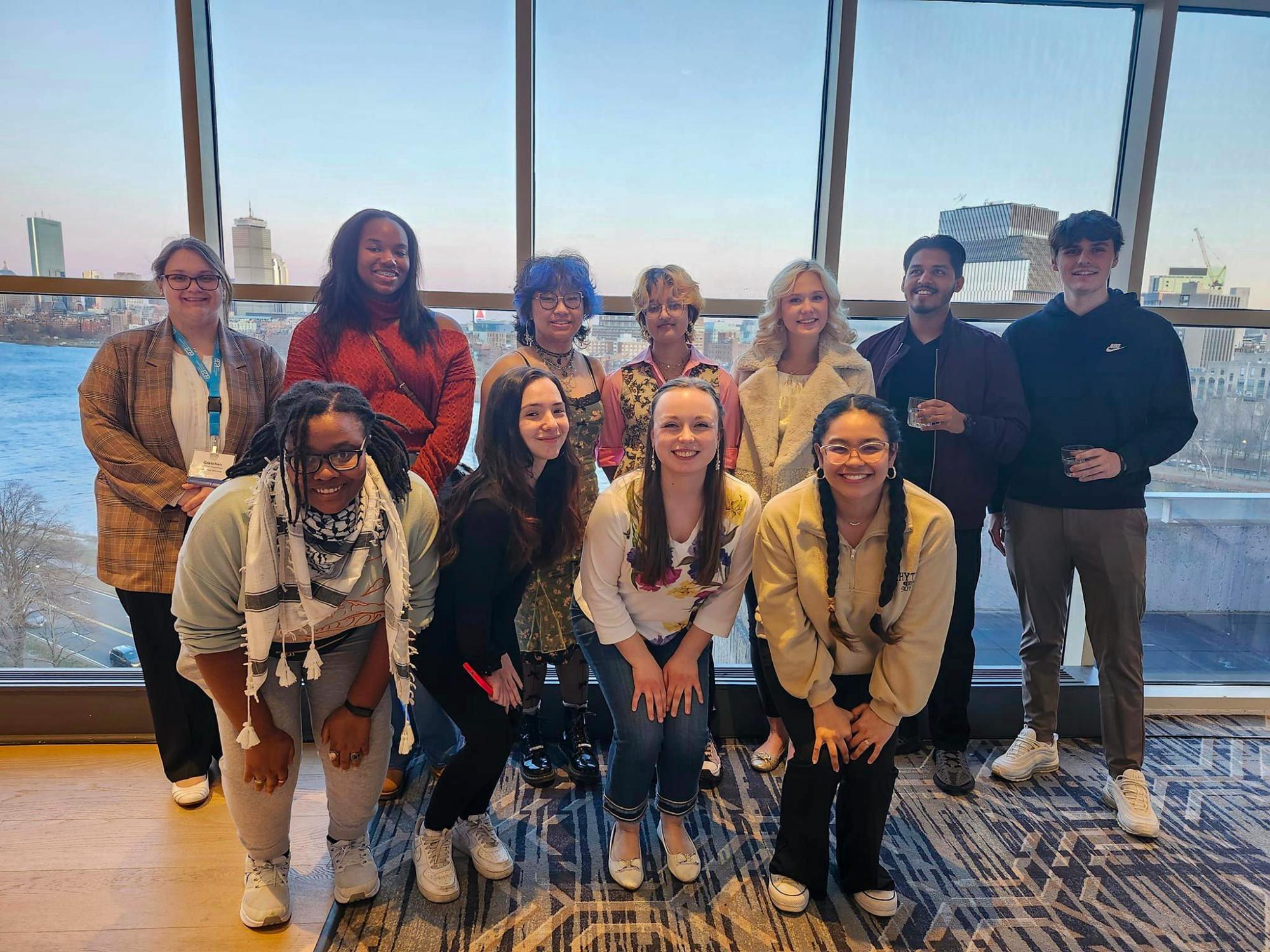 group of people standing in front of window with city view