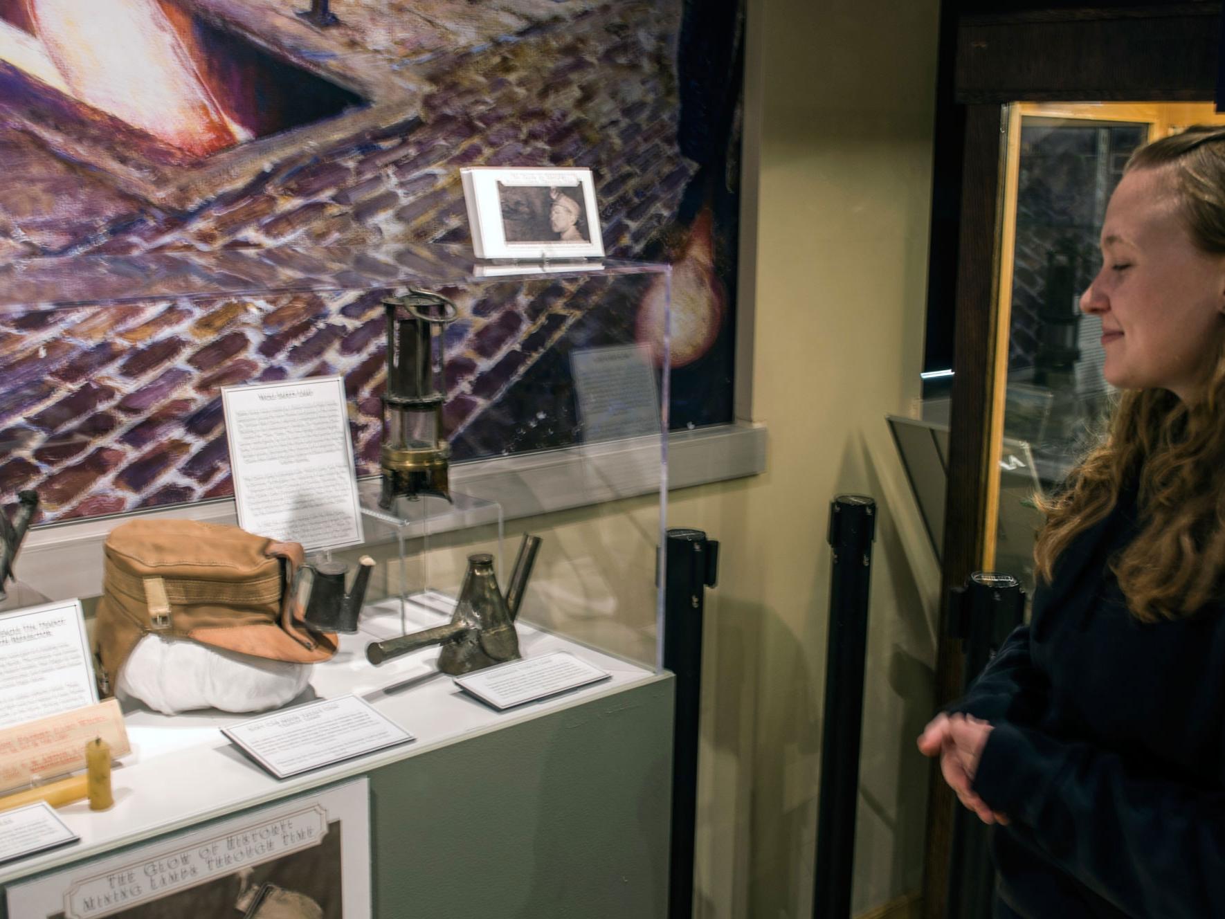 Student Morgan E. Riley shows off a case of artifacts she helped to research and display within the EMS Museum.