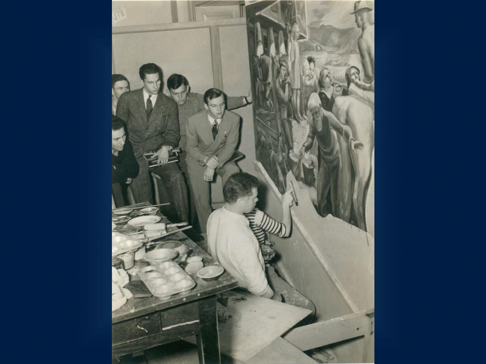 Students gather around Henry Poor as he works on the mural that became the Old Main frescoes.
