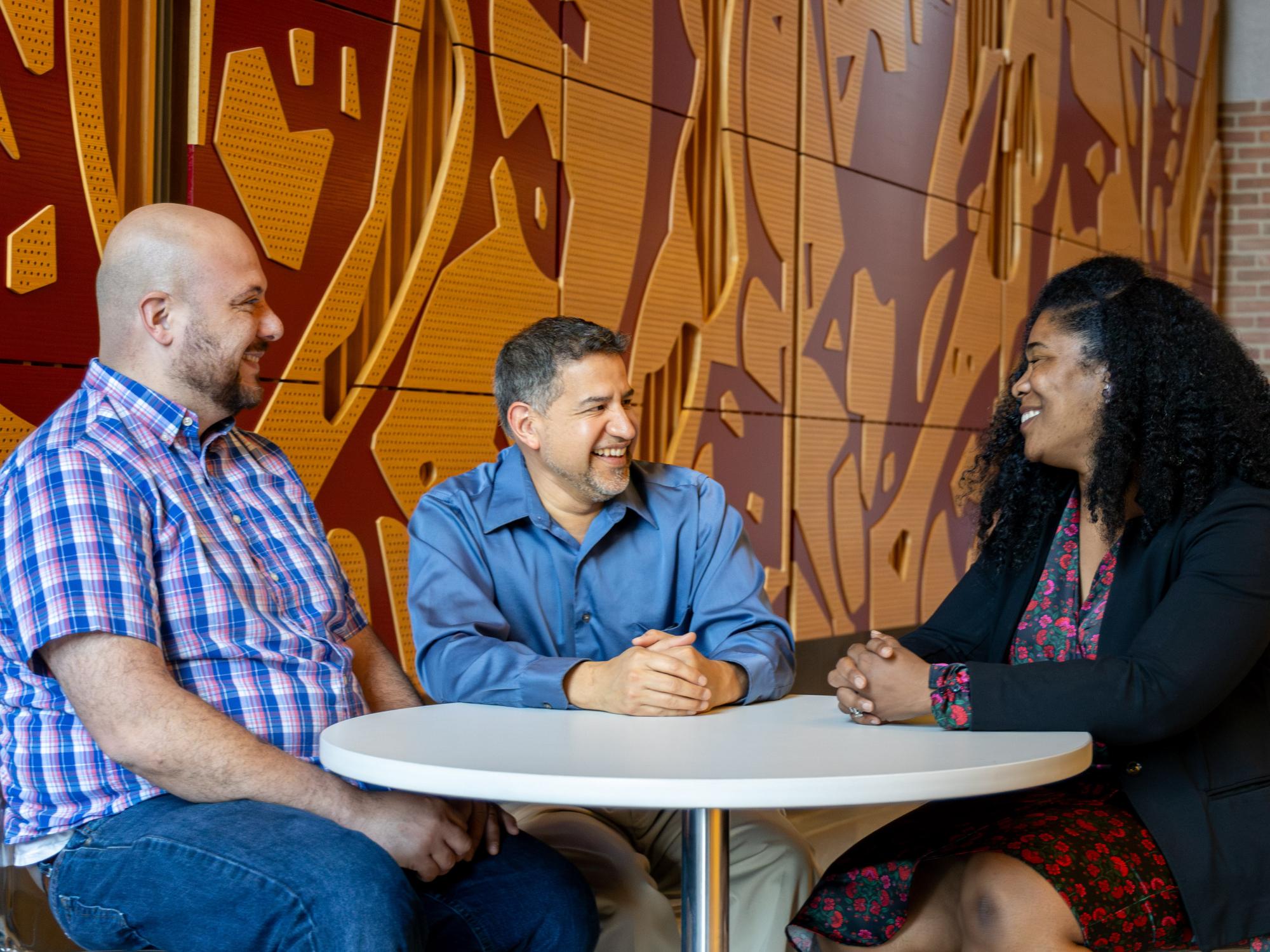 MFAP participants converse while sitting at a table. 