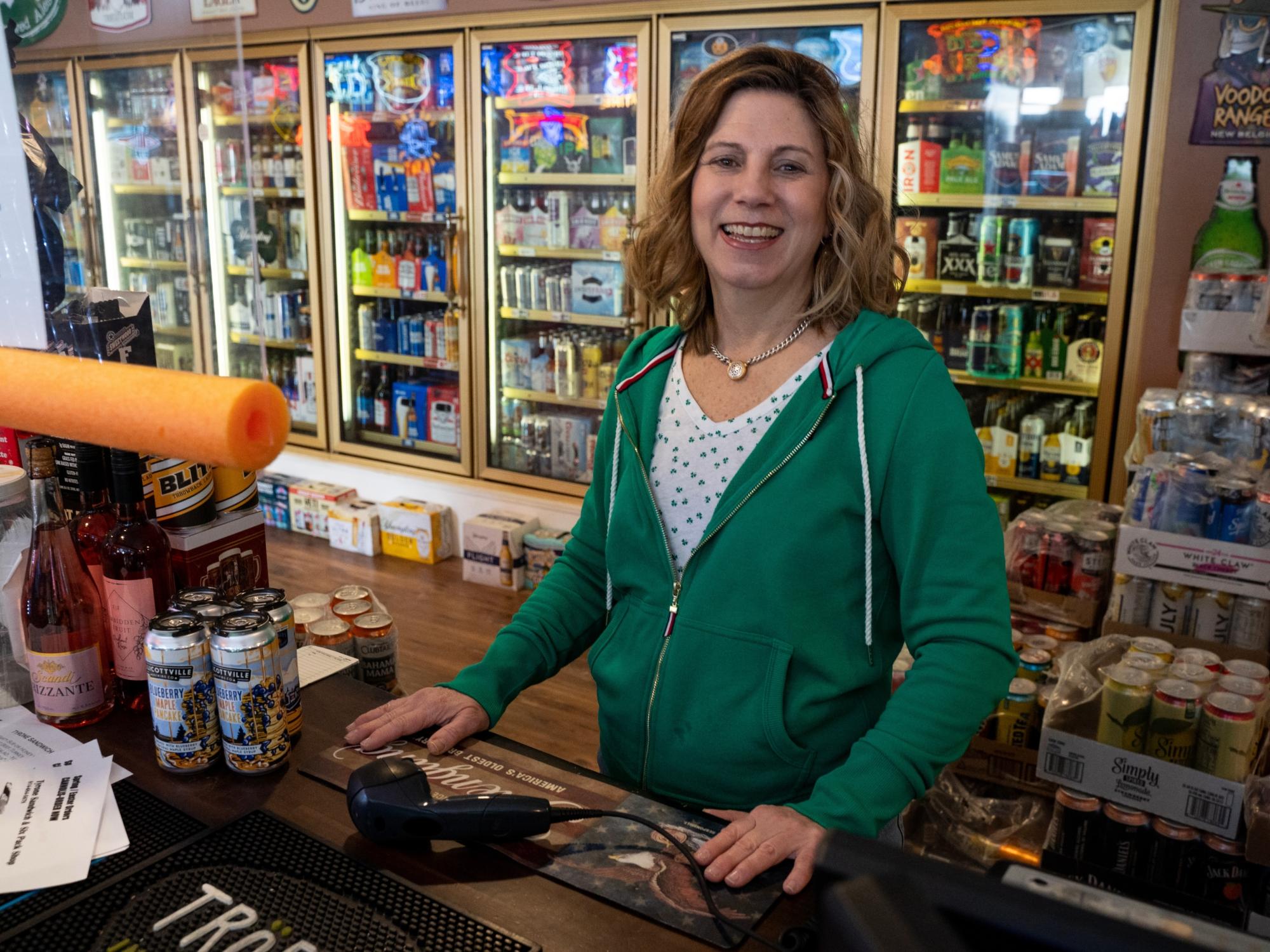 Woman standing at sales counter in store.