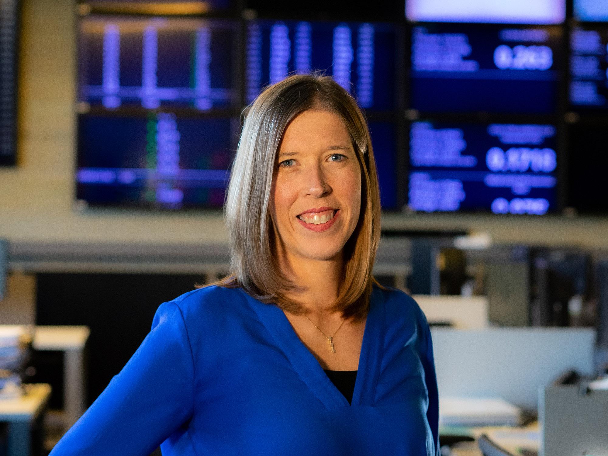 a portrait of a woman with screens blurred in the background