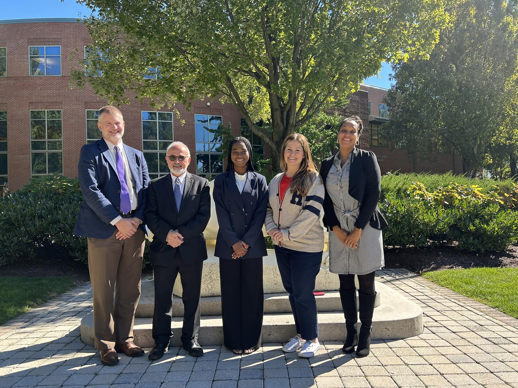 Group photo of five people in front of the Nittany Lion statue at Penn State Harrisburg