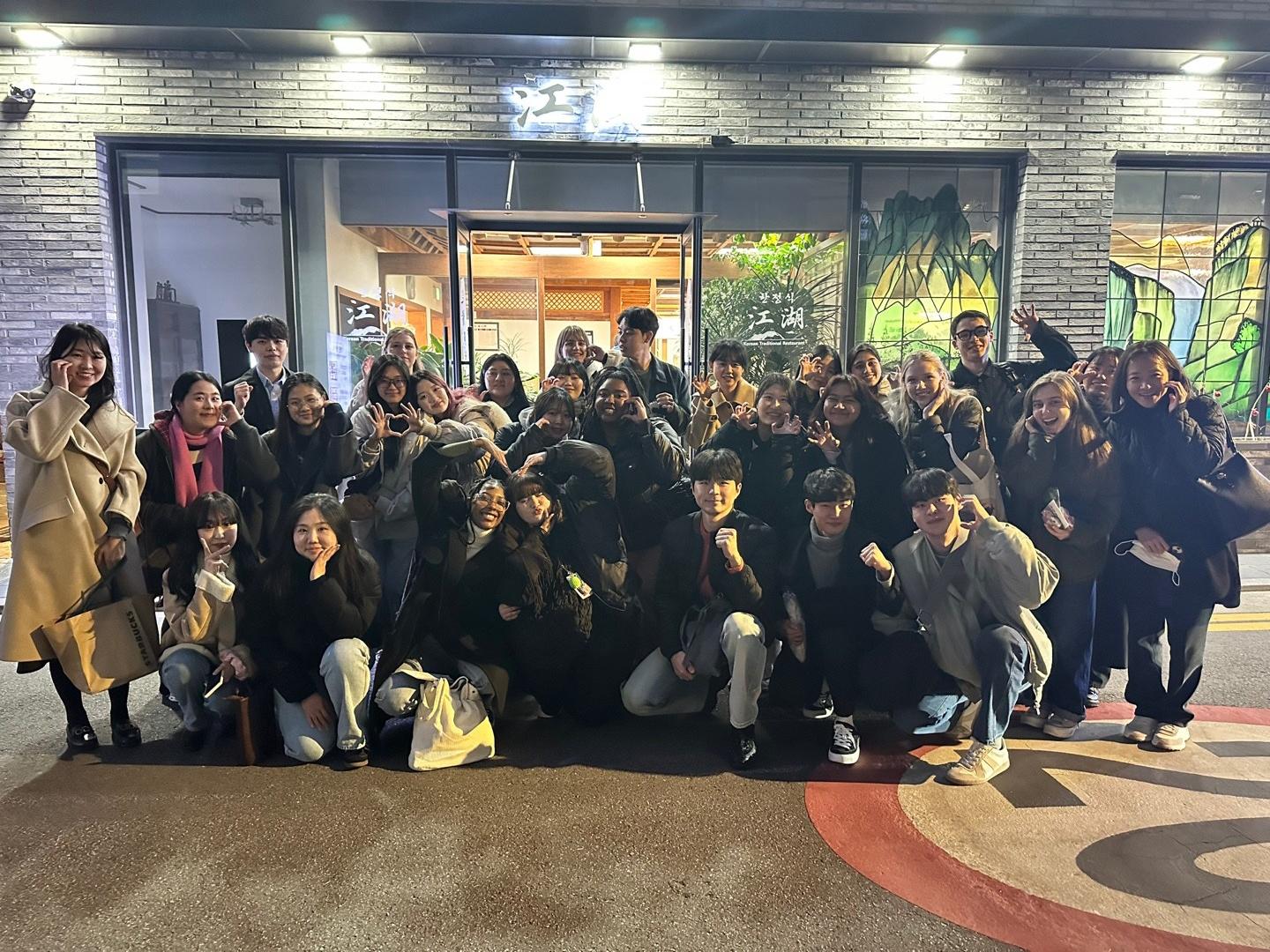 Penn State students and their Korean language partners in a group picture outside a restaurant.