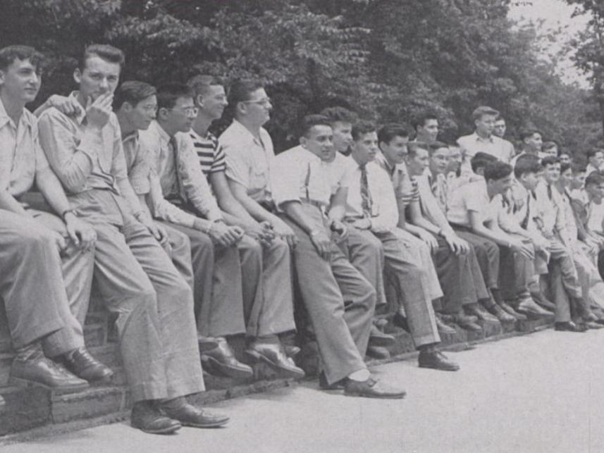 A group of soldiers-to-be sitting on a stone wall