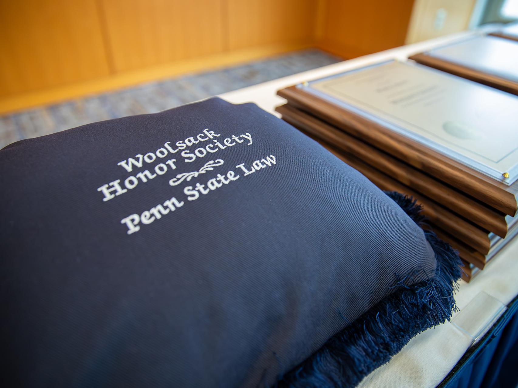 Commemorative pillow embroidered with “Penn State Law Woolsack Honor Society.”