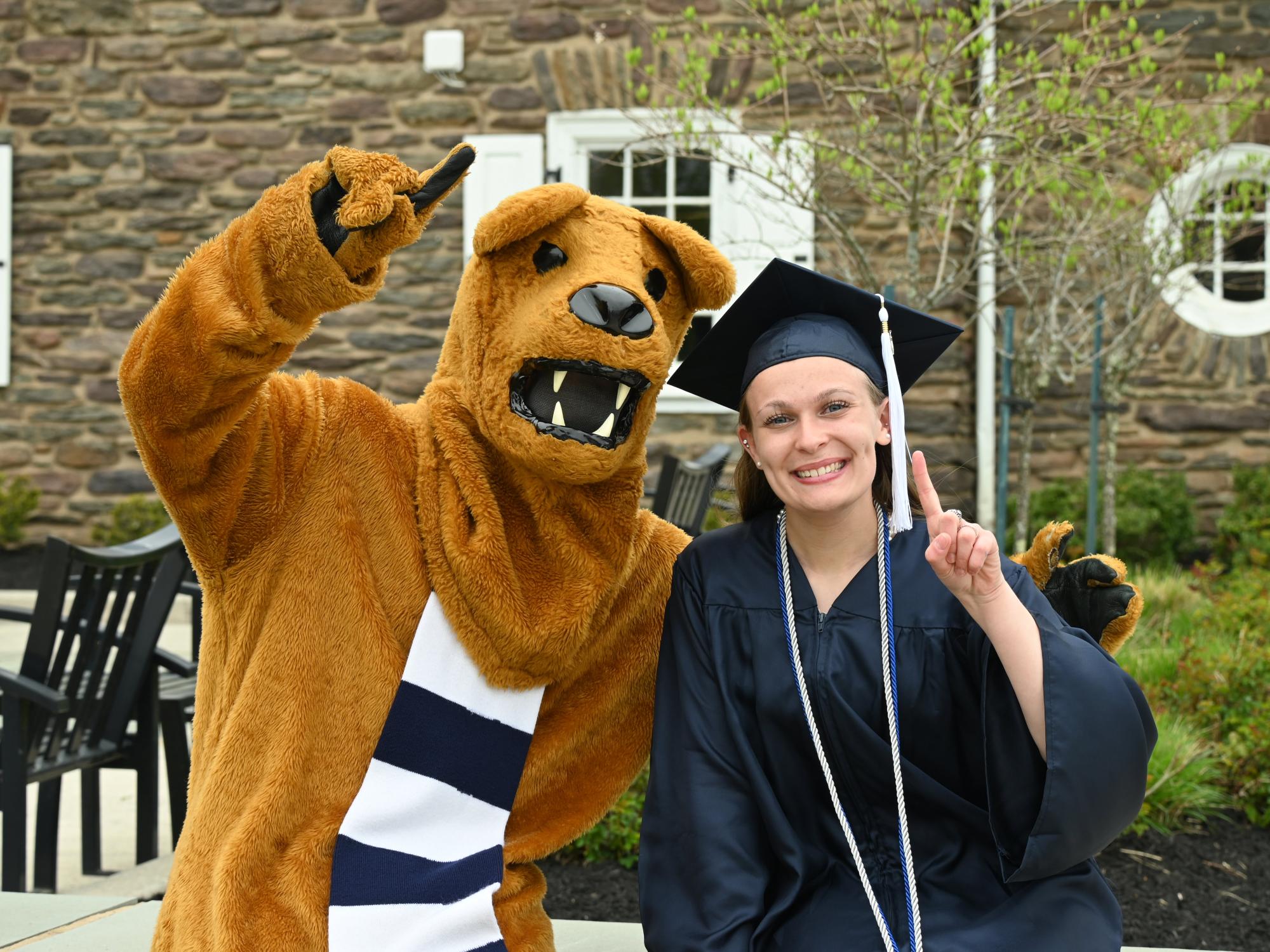 Nittany Lion mascot and female graduate outdoors