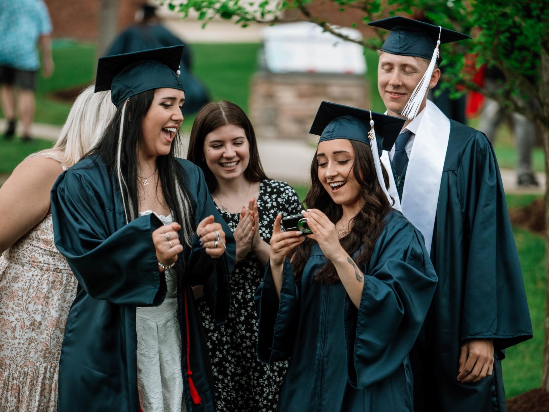 Graduates and students gather to look at camera photo