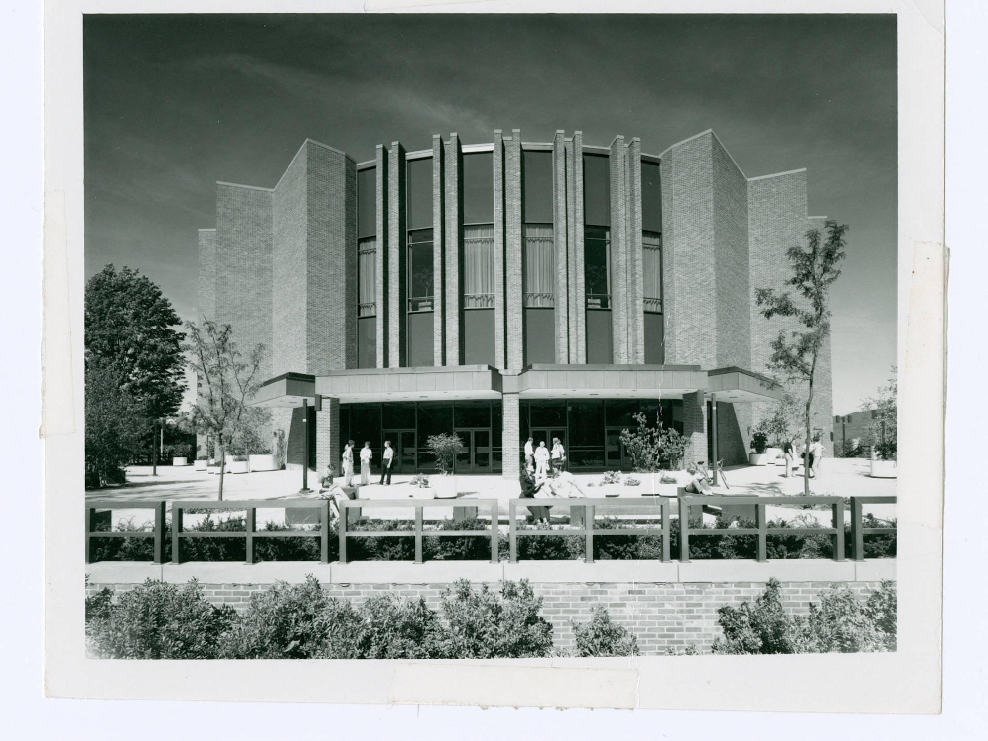 An archive image shows a brick auditorium shortly after its opening.