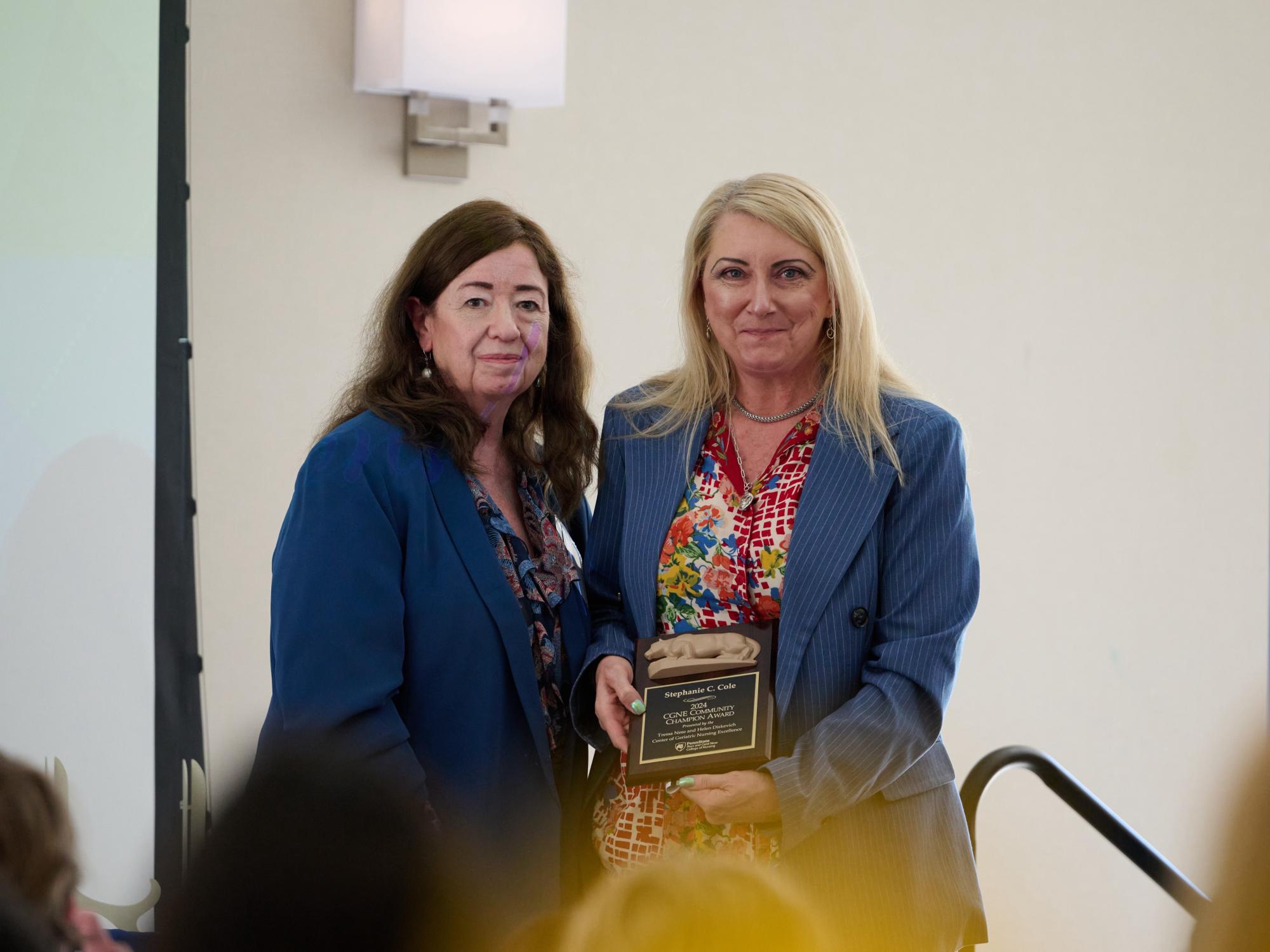 Dr. Marie Boltz (left) presents the CGNE Community Champion Award to Stephanie C. Cole.
