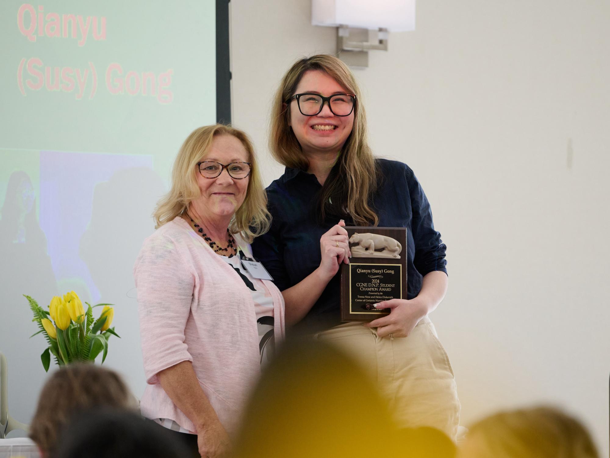 Assistant Teaching Professor Sheilah Yohn presents this year’s CGNE D.N.P. Student Champion Award to Qianyu (Susy) Gong (right).