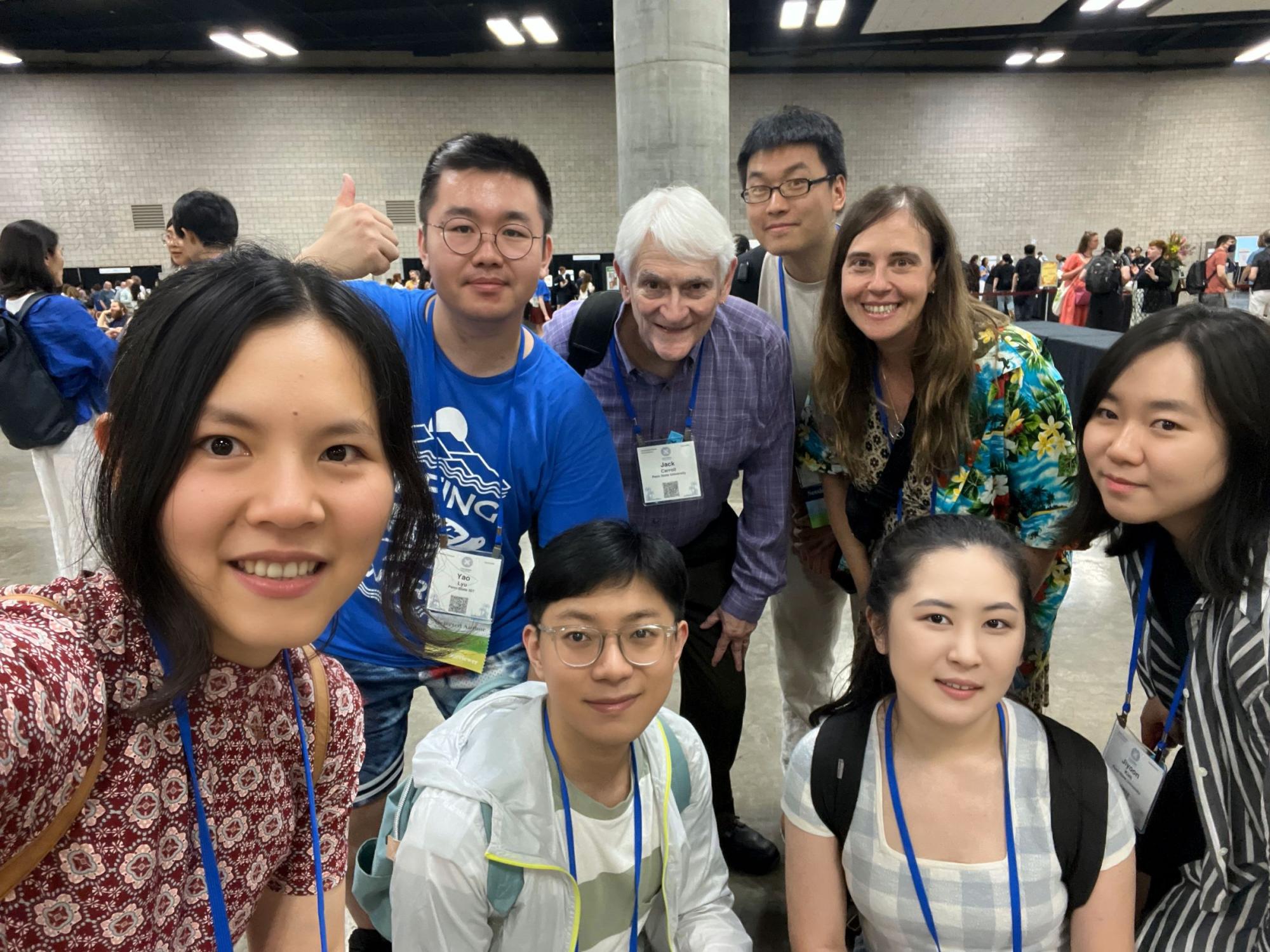 eight people wearing lanyards pose at research conference