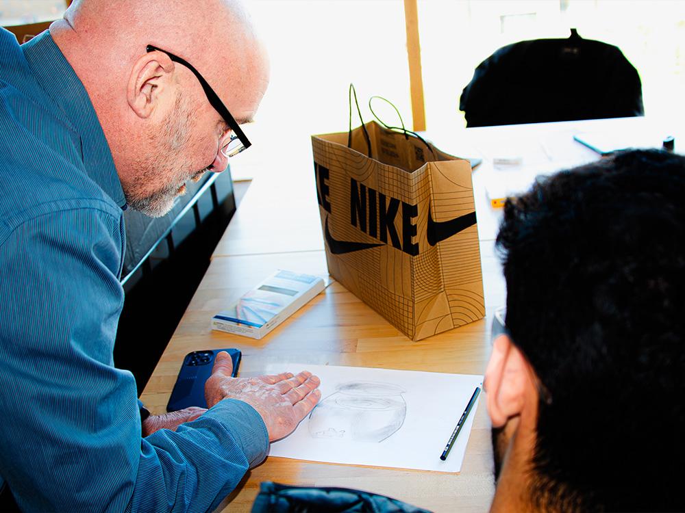 instructor explains how to draw detail of sketch to student