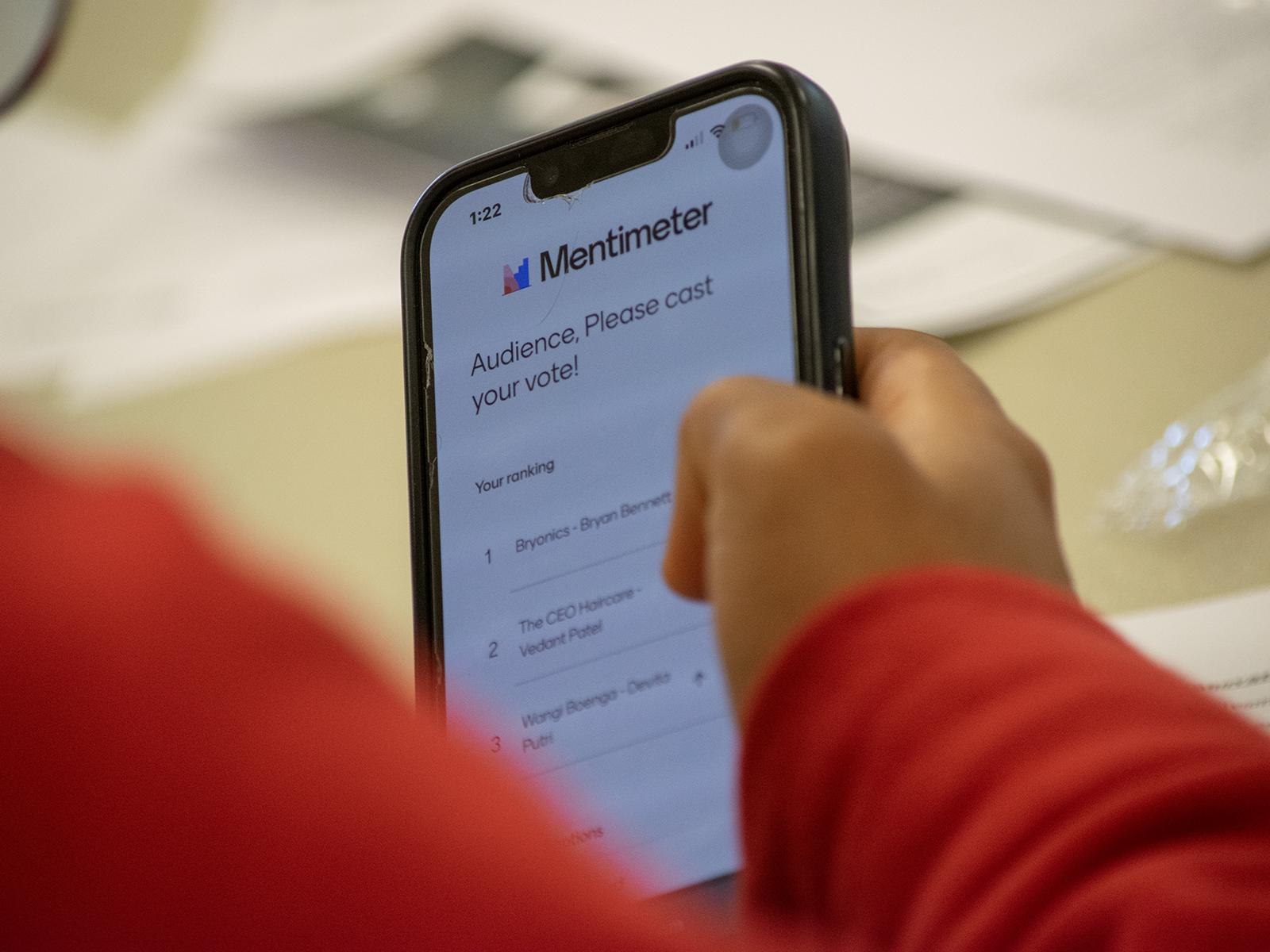 Closeup of a cell phone, showing someone voting during a student pitch competition