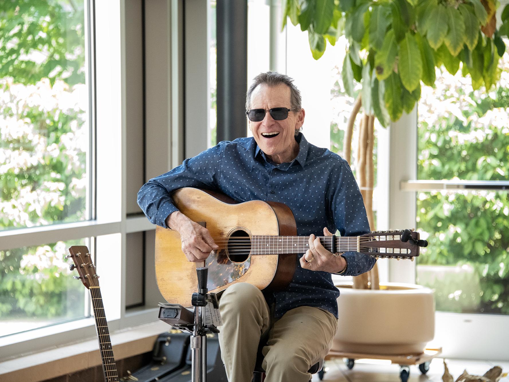 Smiling guitarist plays live music.