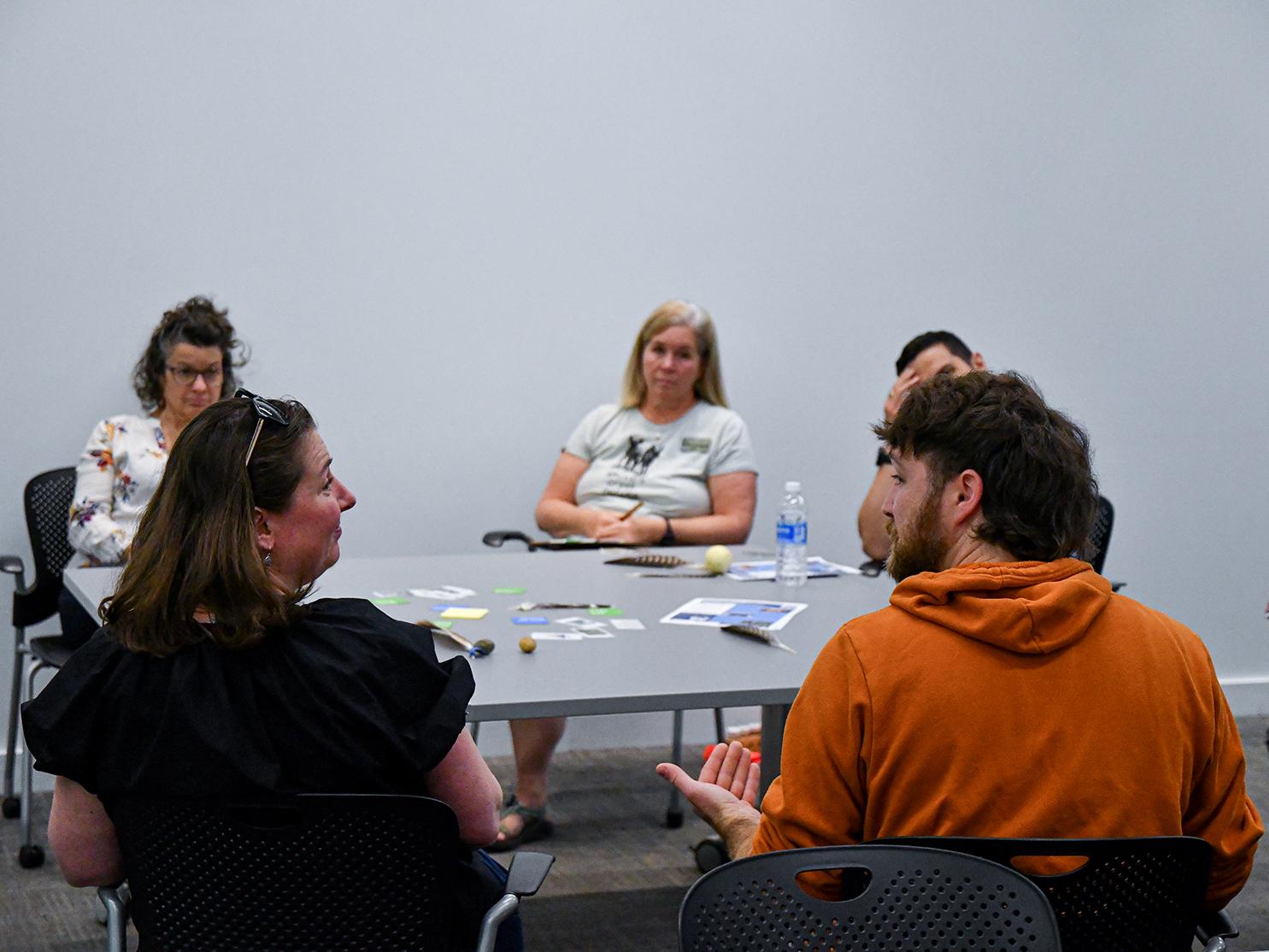 A group of people sit around a table having a discussion