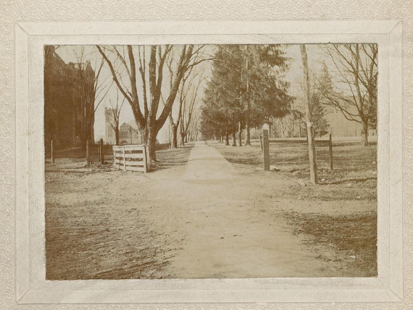A wooden fence at the entrance to campus in the late 1800s