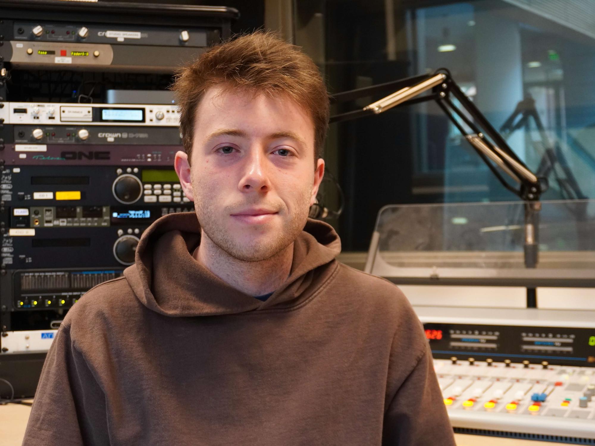 Man sitting in an on-air radio studio.
