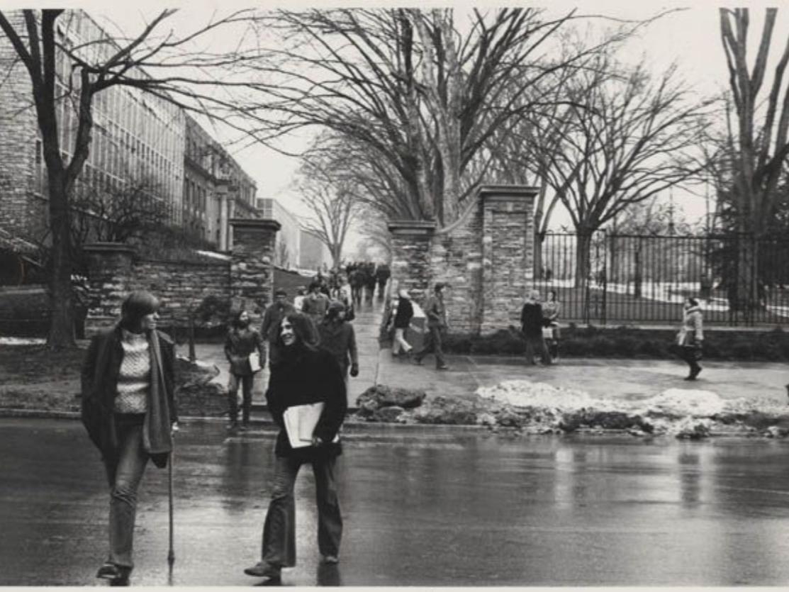 Students crossing the street in front of the Allen Street gates
