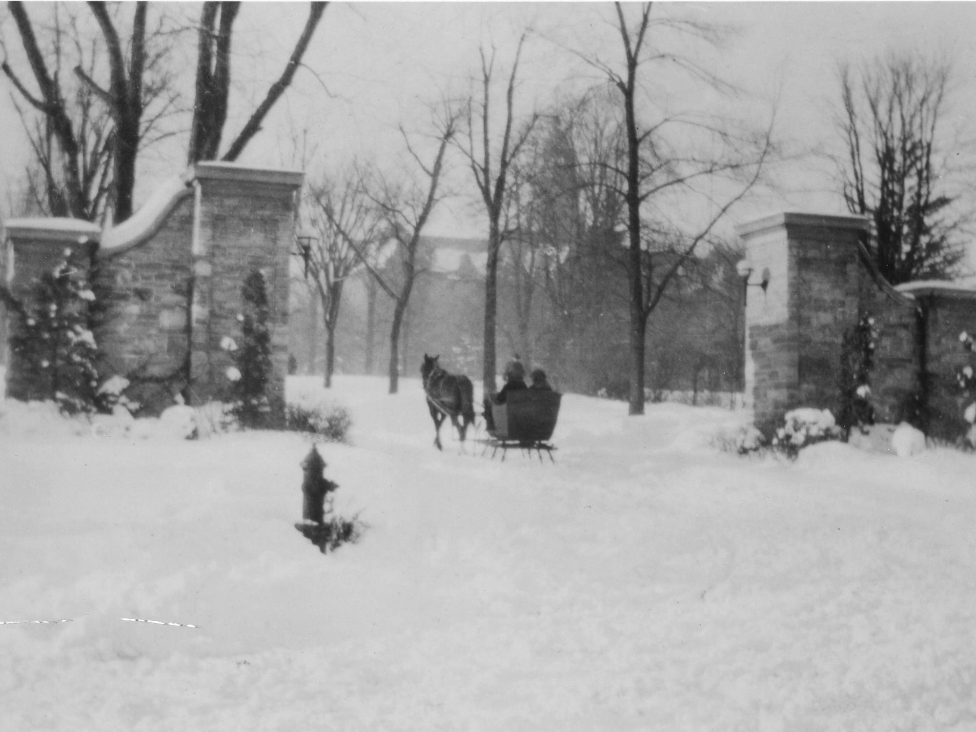 A horse-drawn carriage enters campus through the main gateway