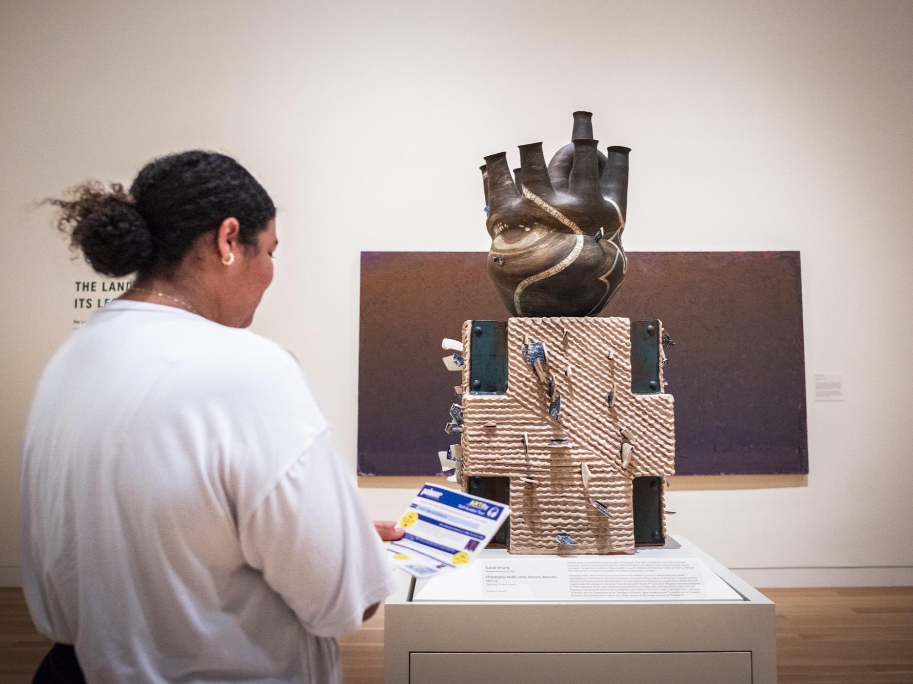 A student in front of a sculpture