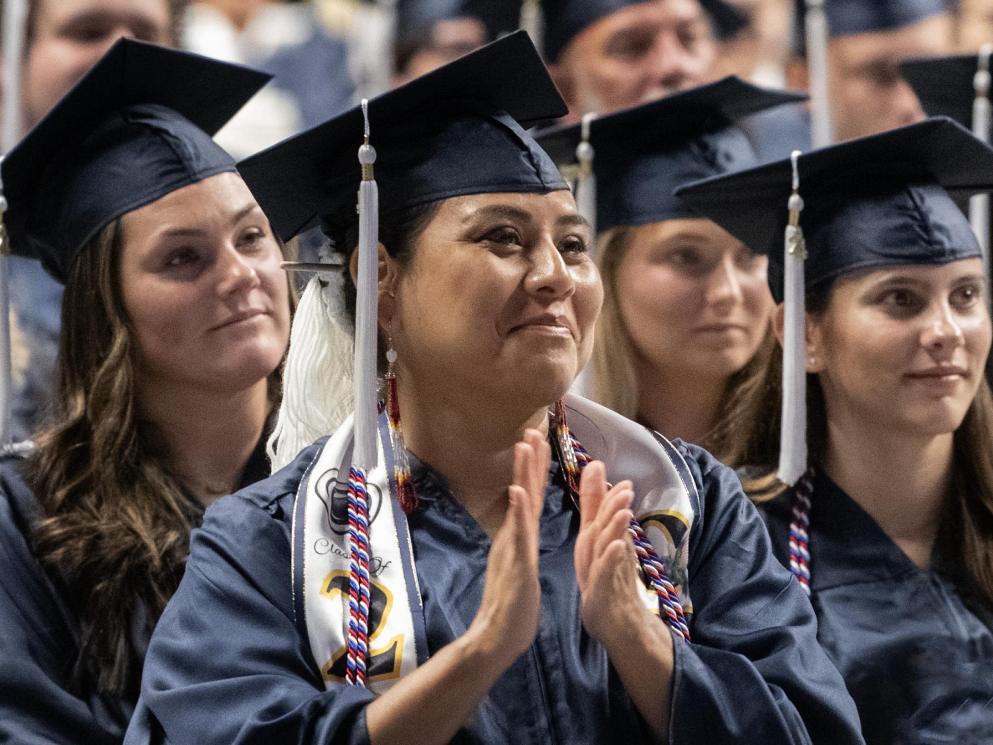 graduate applauds at summer commencement