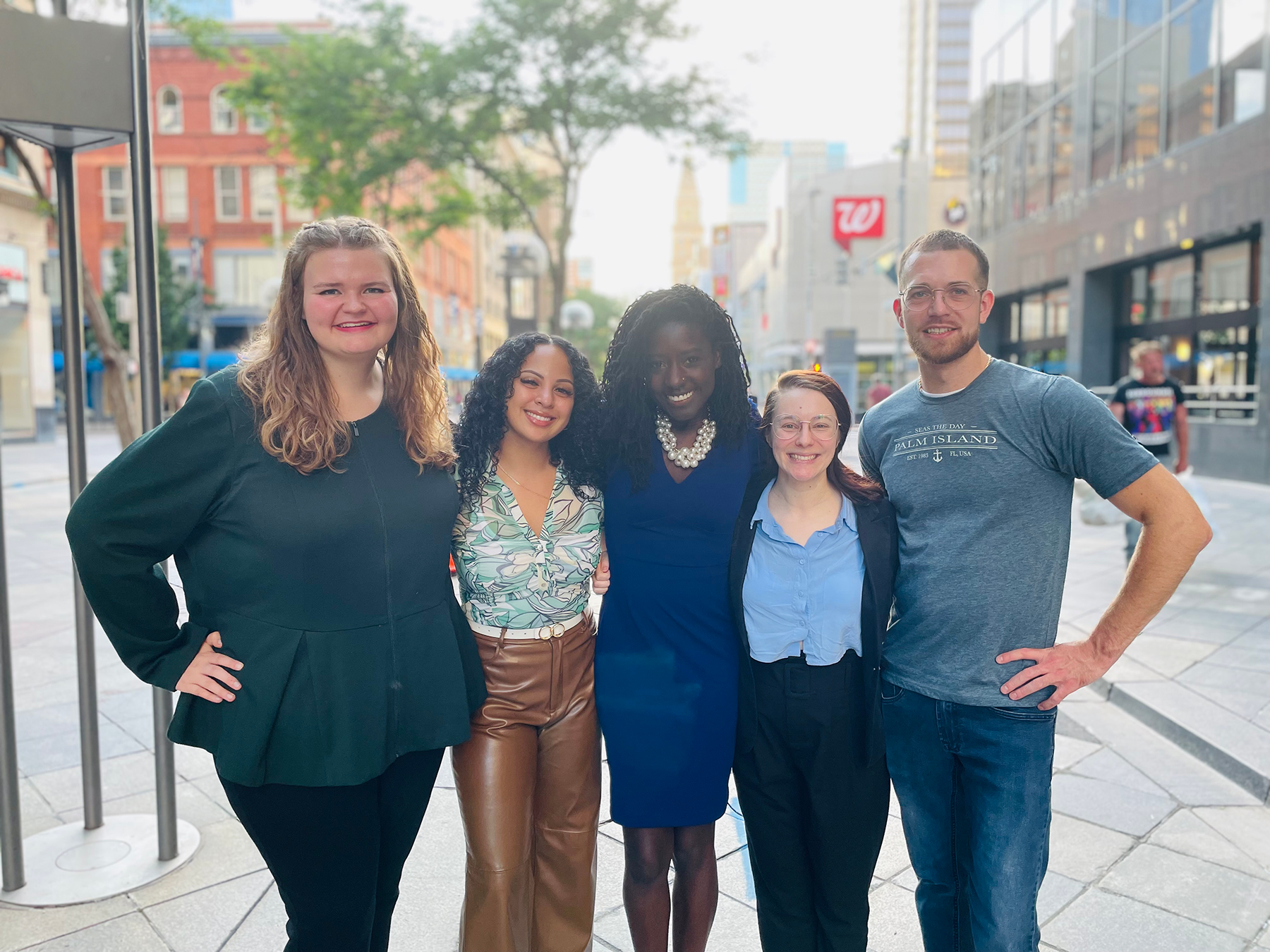 Five people standing on a sidewalk
